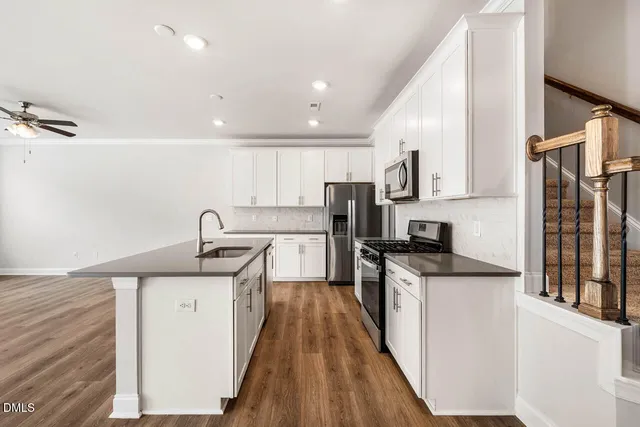 a kitchen with stainless steel appliances granite countertop a sink stove and refrigerator