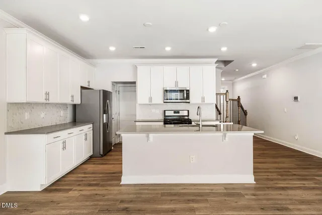 a kitchen with stainless steel appliances a refrigerator sink and microwave