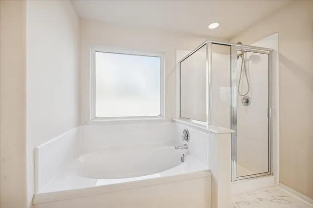 a white bath tub sitting next to a shower