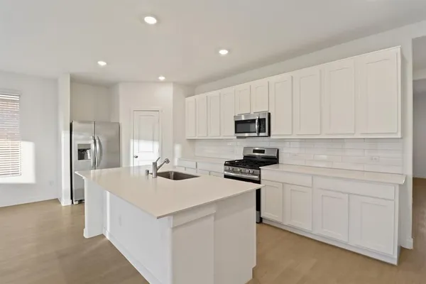 a large kitchen with stainless steel appliances kitchen island a large counter top and a stove top oven