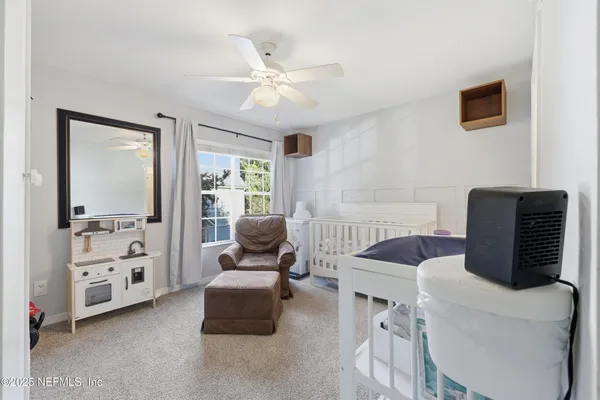 a bedroom with a bed a chandelier and a window