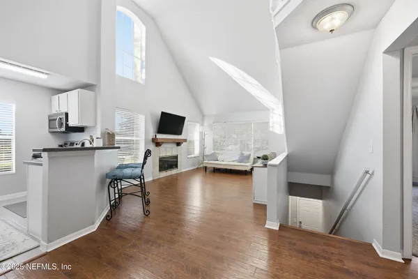 a view of a kitchen with furniture and wooden floor