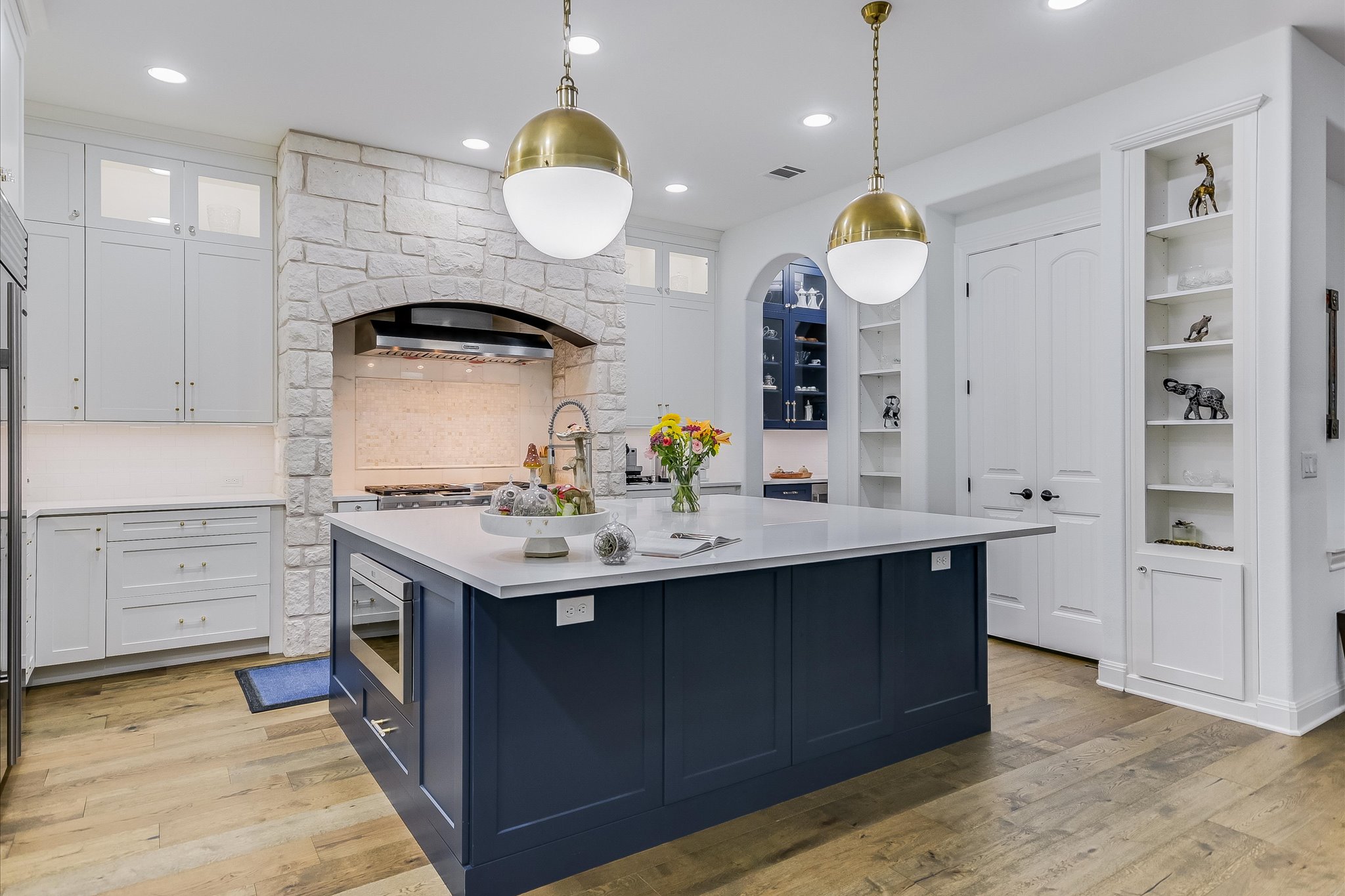 2625 Arion Circle Austin, TX 78730 - Photo 4 of 32 Kitchen featuring white cabinets, light countertops, light wood finished floors, recessed lighting, and decorative light fixtures