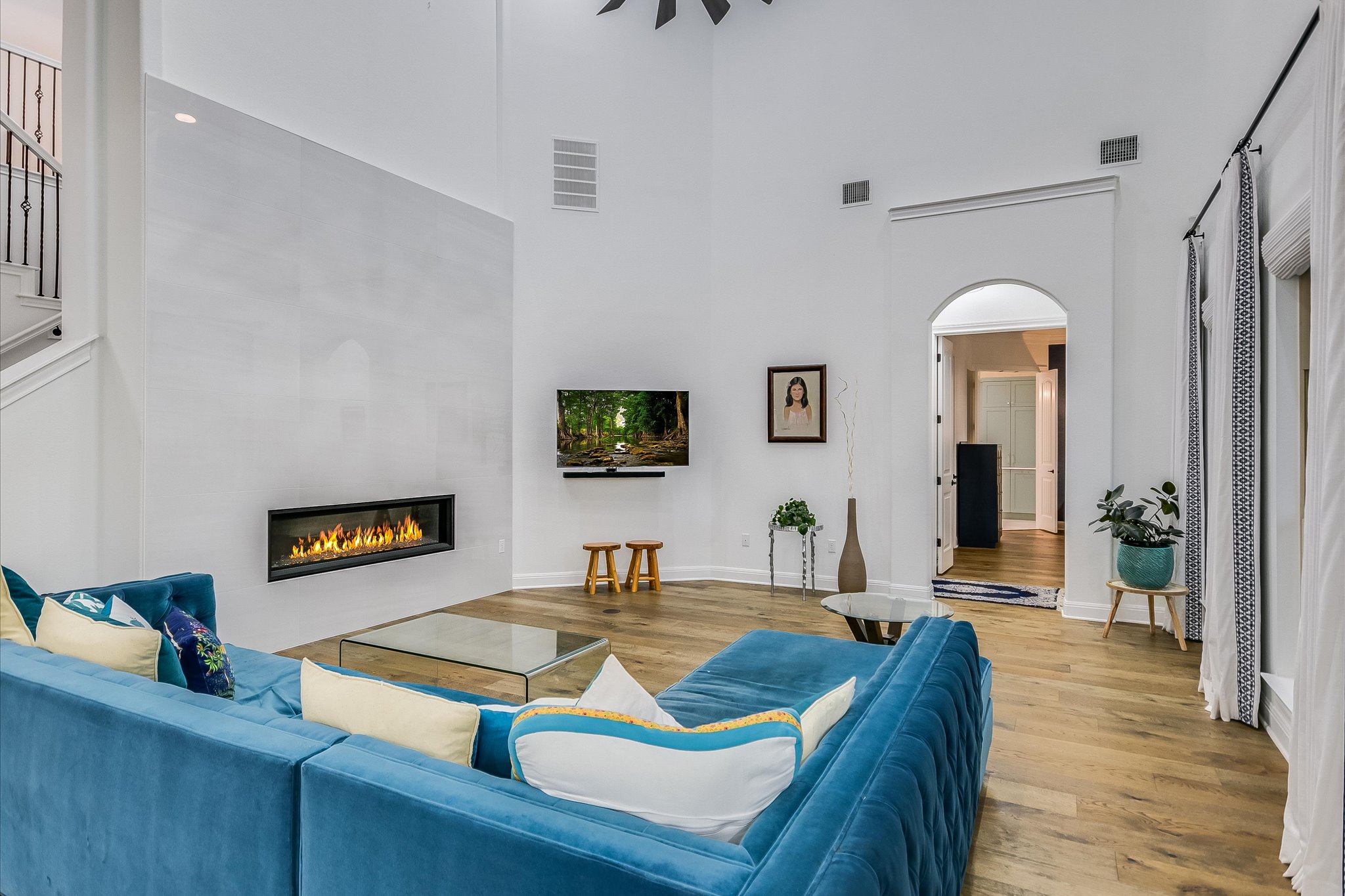 2625 Arion Circle Austin, TX 78730 - Photo 7 of 32 Living room with a towering ceiling, wood finished floors, arched walkways, and a tiled fireplace