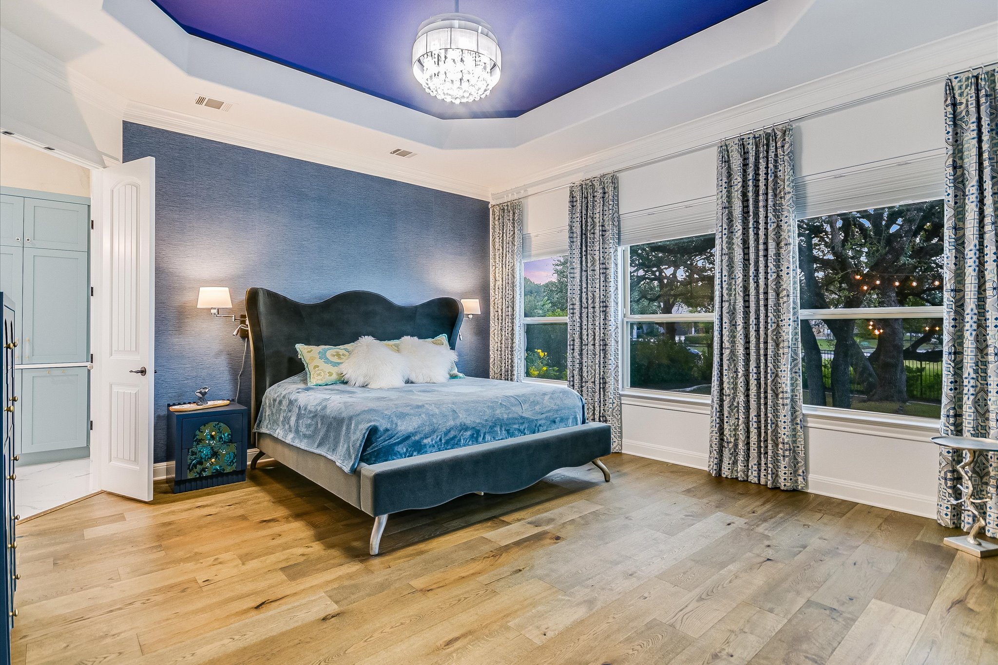 2625 Arion Circle Austin, TX 78730 - Photo 8 of 32 Bedroom featuring a tray ceiling, ornamental molding, light wood-type flooring, and a chandelier