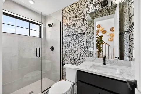 a bathroom with a sink a toilet and shower