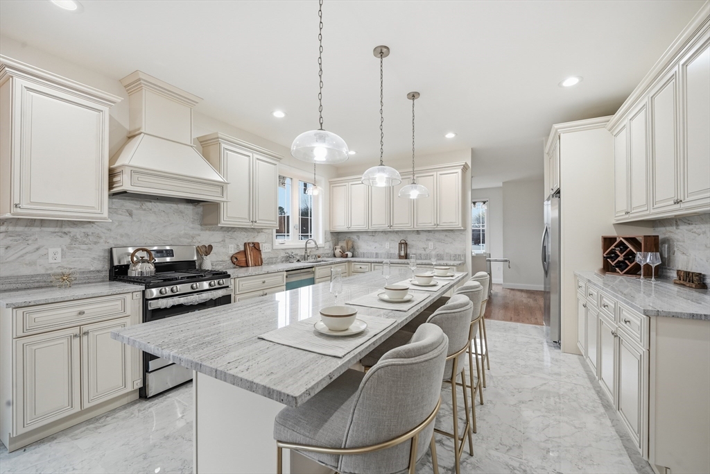 110 West Crystal Brook Drive Springfield, MA 01118 - Photo 14 of 40 a kitchen with stainless steel appliances granite countertop a stove a sink a kitchen island a refrigerator a stove and white cabinets