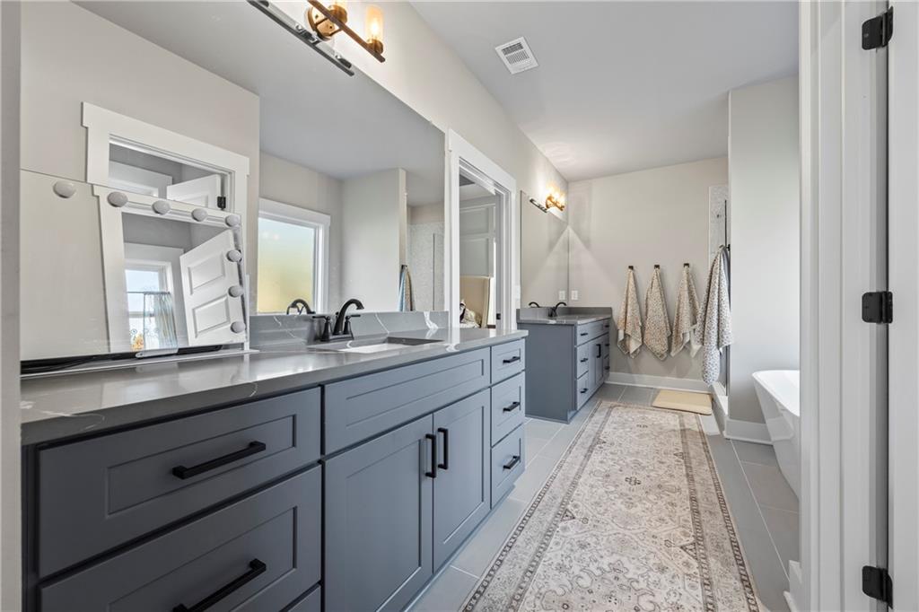 152 White Oak Way Monroe, GA 30655 - Photo 25 of 65 a spacious bathroom with double vanity and mirrors