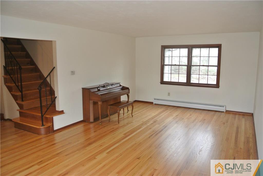 17 Woodruff Road Edison, NJ 08820 - Photo 13 of 25 an empty room with wooden floor staircase and windows