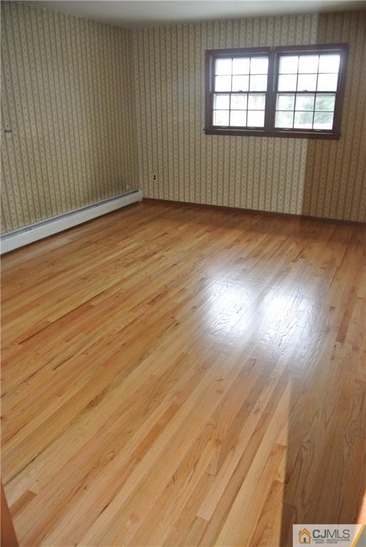 17 Woodruff Road Edison, NJ 08820 - Photo 17 of 25 an empty room with wooden floor and windows