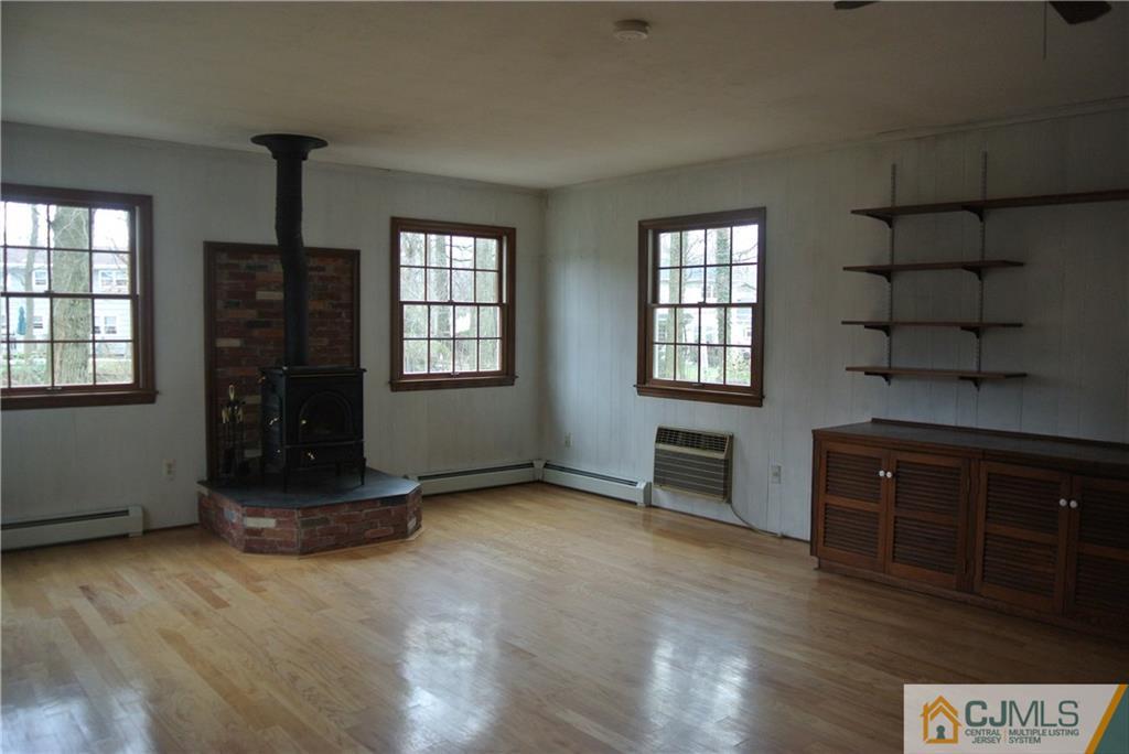 17 Woodruff Road Edison, NJ 08820 - Photo 4 of 25 an empty room with a fireplace and wooden floor
