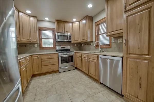 a kitchen with white cabinets stainless steel appliances and sink