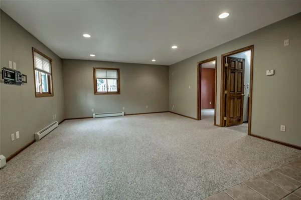 an empty room with closet and windows