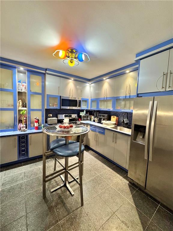 3105 Ave V, Unit 2E Brooklyn, NY 11229 - Photo 4 of 9 a kitchen with stainless steel appliances kitchen island granite countertop a sink and cabinets