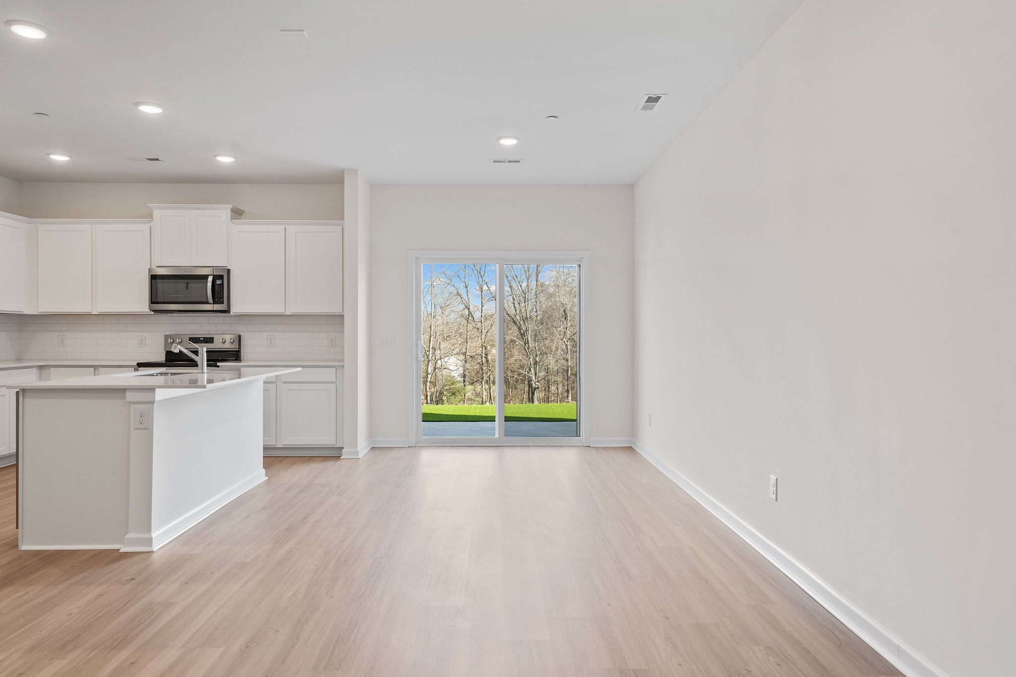 7124 Mapleside Lane Fairview, TN 37062 - Photo 15 of 30 a kitchen with white cabinets and wooden floor