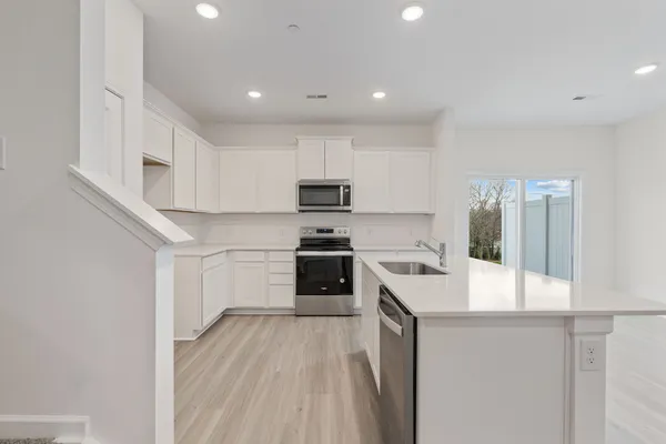 a kitchen with white cabinets and stainless steel appliances