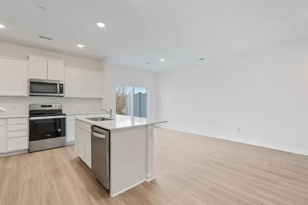 a kitchen with a stove a sink and a microwave