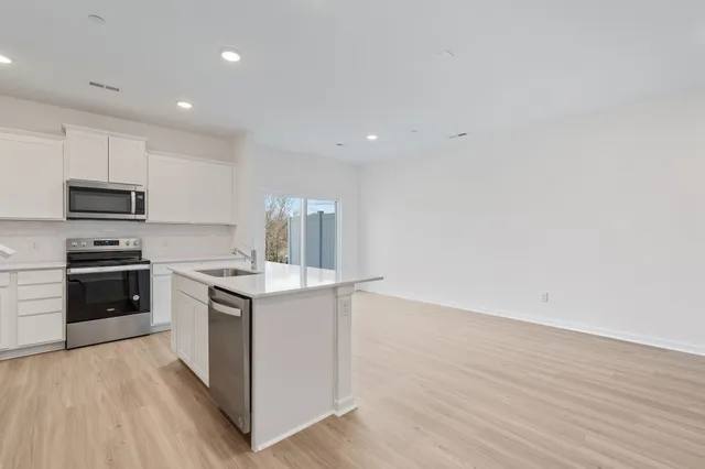 a kitchen with a stove a sink and a microwave