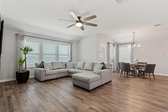 a living room with furniture and a wooden floor