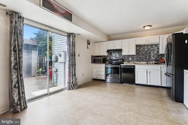 a kitchen with stainless steel appliances kitchen island granite countertop a stove a refrigerator a sink a oven with wooden cabinets