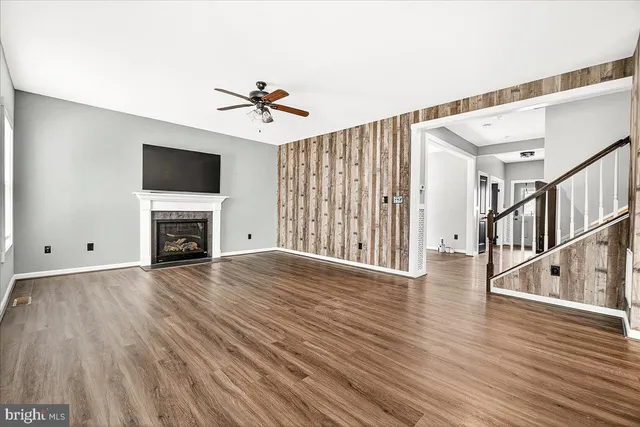 a view of empty room with fireplace and wooden floor