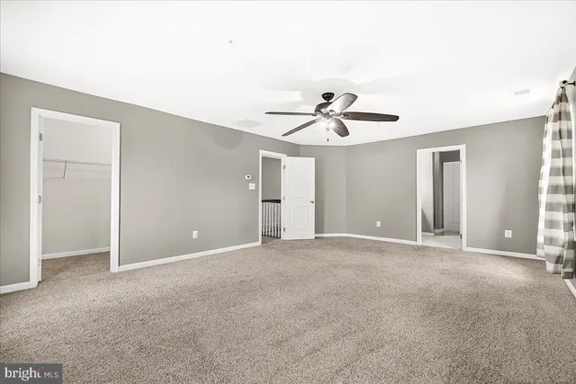 a view of an empty room with a ceiling fan