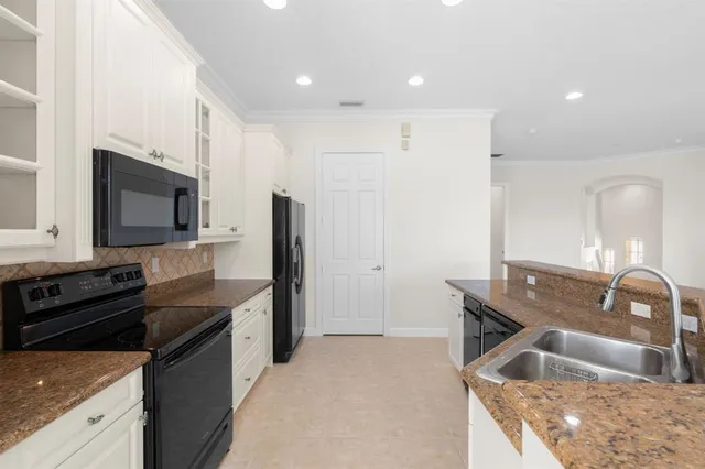a kitchen with granite countertop a sink and a stove top oven with wooden floor
