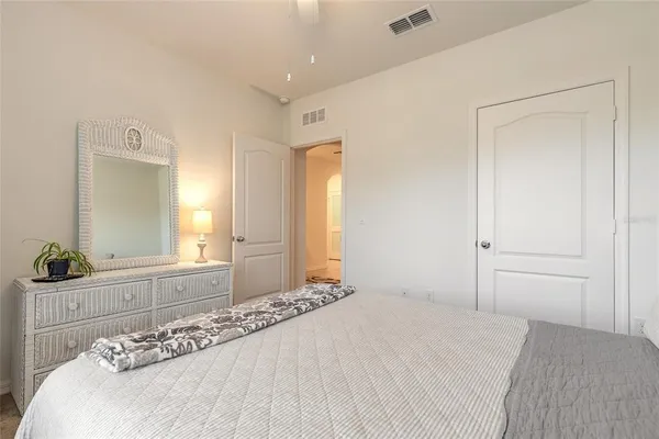 a bedroom with a bed and a large mirror