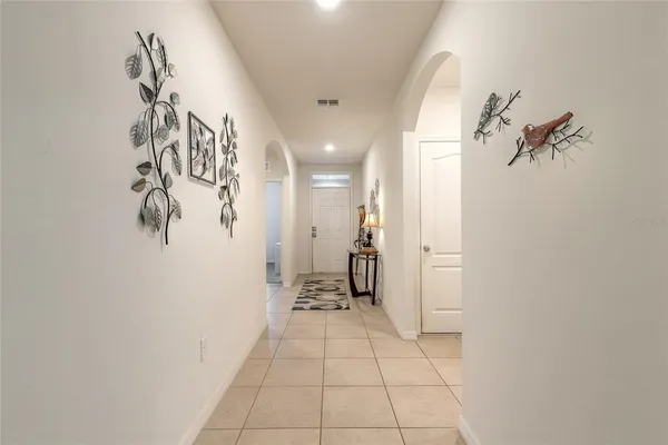 a view of a hallway with wooden floor and a bathroom