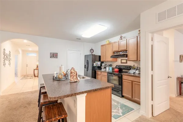 a kitchen with stainless steel appliances granite countertop a sink refrigerator and cabinets