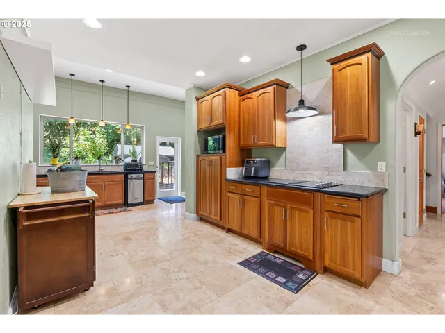a kitchen with stainless steel appliances granite countertop a stove a sink and a refrigerator