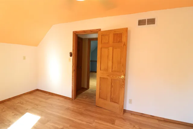 an empty room with wooden floor and closet