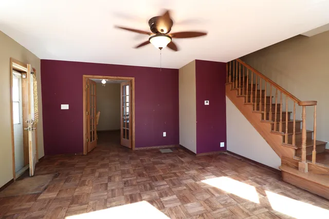 a view of a livingroom with a ceiling fan and entryway