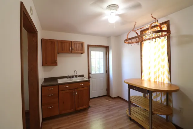 a kitchen with granite countertop a sink cabinets and wooden floor