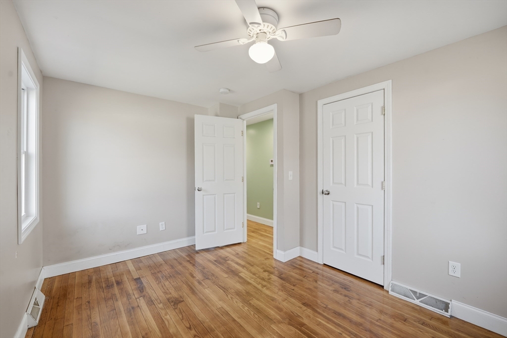 30 Lively Lane Springfield, MA 01109 - Photo 22 of 33 an empty room with wooden floor fan and windows