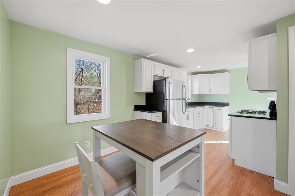 30 Lively Lane Springfield, MA 01109 - Photo 7 of 33 a kitchen with stainless steel appliances kitchen island a table chairs in it and wooden floors