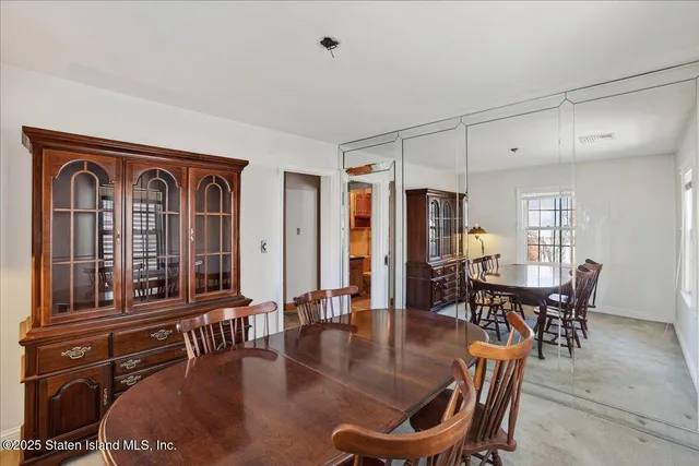 a dining room with furniture window and wooden floor