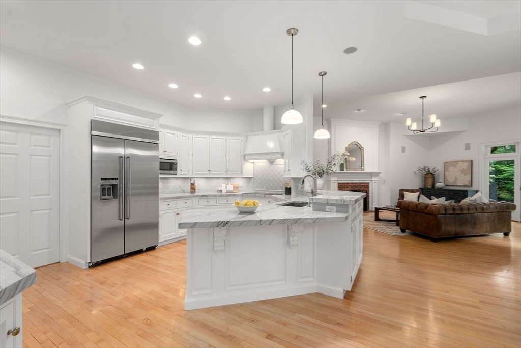 20 Flint Road Concord, MA 01742 - Photo 16 of 34 a large kitchen with kitchen island a sink a center island stainless steel appliances and a fireplace