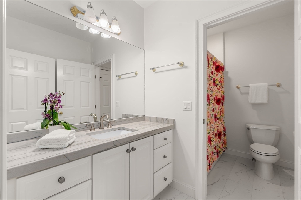 20 Flint Road Concord, MA 01742 - Photo 22 of 34 a bathroom with a granite countertop sink a toilet and a mirror