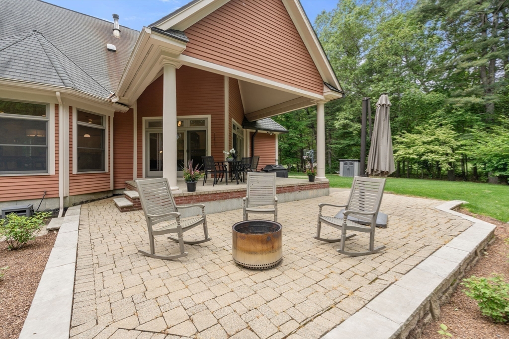20 Flint Road Concord, MA 01742 - Photo 30 of 34 a view of a patio with table and chairs potted plants and floor to ceiling window
