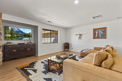 a spacious bedroom with a bed a mirror and a lamp on a bookshelf