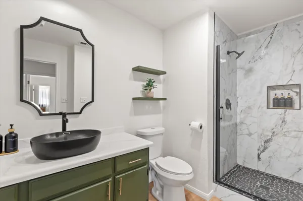 a bathroom with a sink toilet a mirror and shower