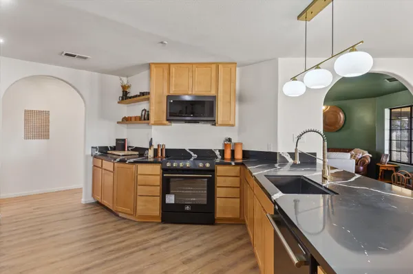 a kitchen with stainless steel appliances granite countertop a sink and a stove