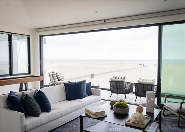 a living room with furniture and floor to ceiling windows