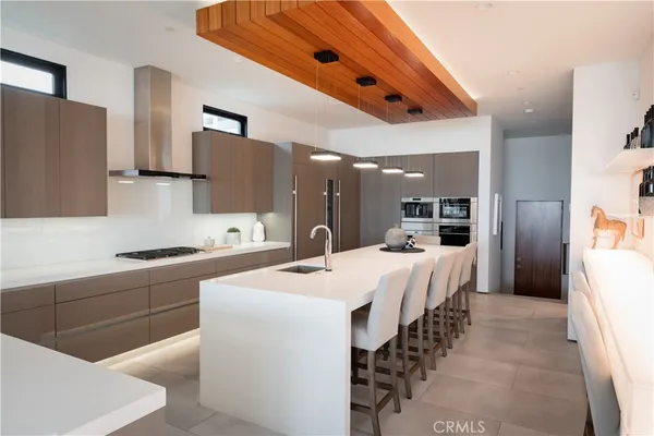 a large kitchen with stainless steel appliances kitchen island a refrigerator sink and a stove