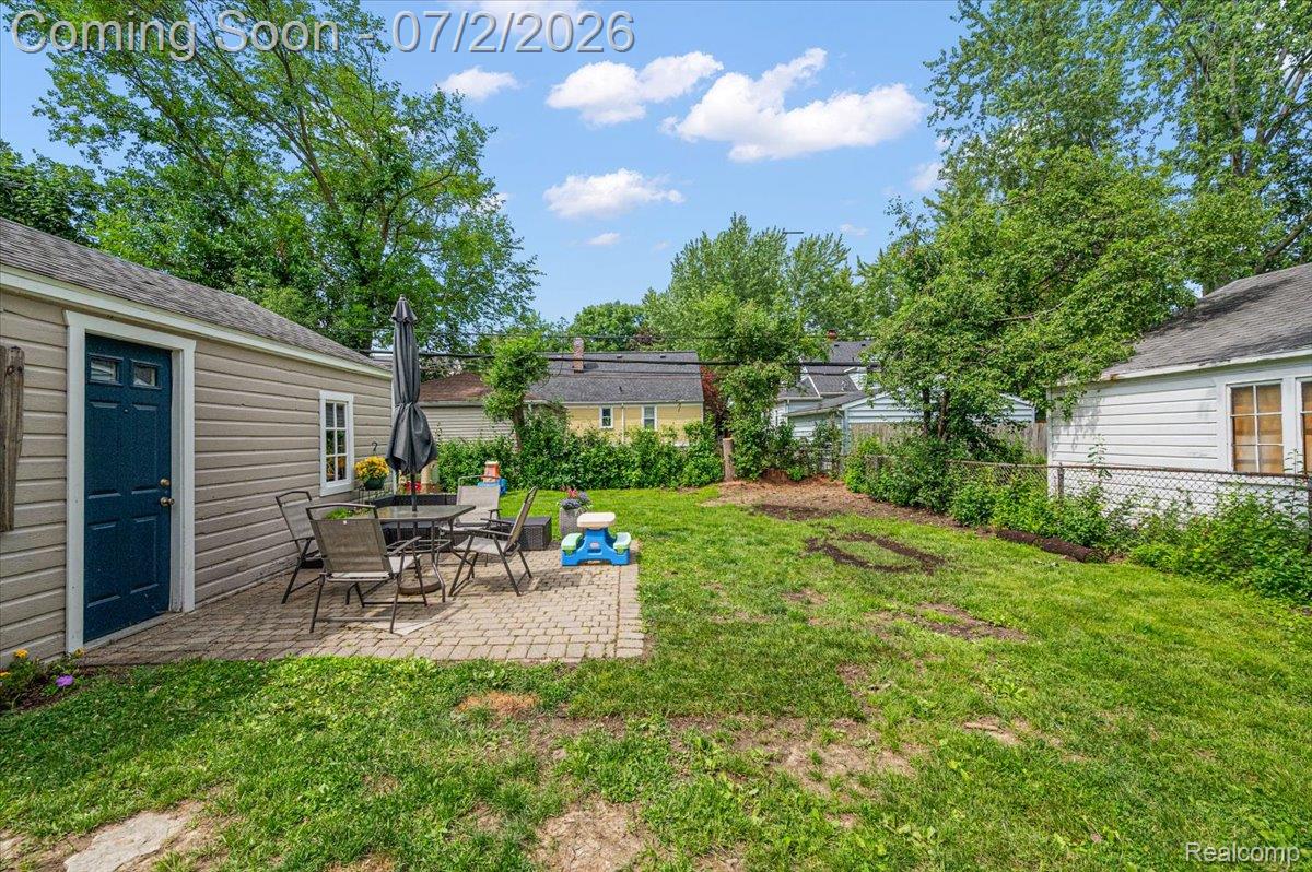 1706 Princeton Road Berkley, MI 48072 - Photo 48 of 49 Expansive backyard featuring a paver patio, mature trees, and a detached outbuilding with siding and a blue entry door