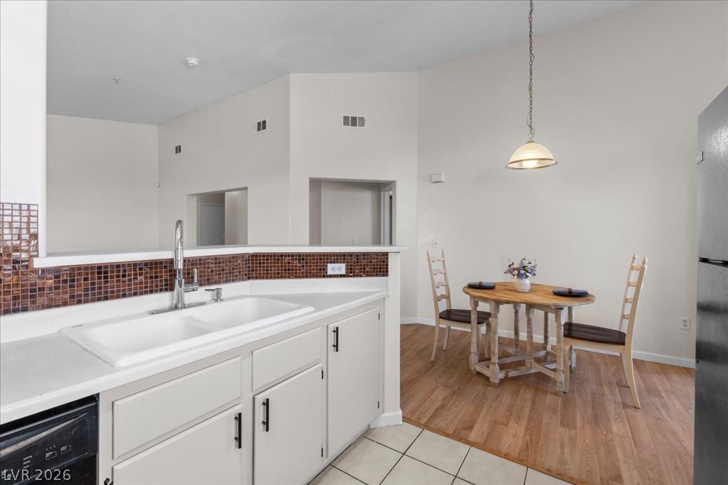 1881 West Alexander Road, Unit 1037 North Las Vegas, NV 89032 - Photo 7 of 31 Prepare meals in a kitchen featuring sleek white cabinetry and a convenient dining area.