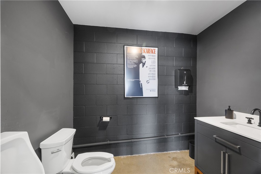 14128 Paramount Boulevard Paramount, CA 90723 - Photo 15 of 42 a bathroom with a toilet a sink and mirror