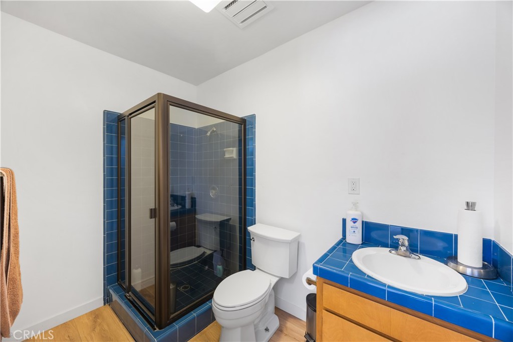 14128 Paramount Boulevard Paramount, CA 90723 - Photo 24 of 42 a bathroom with a granite countertop toilet sink and mirror