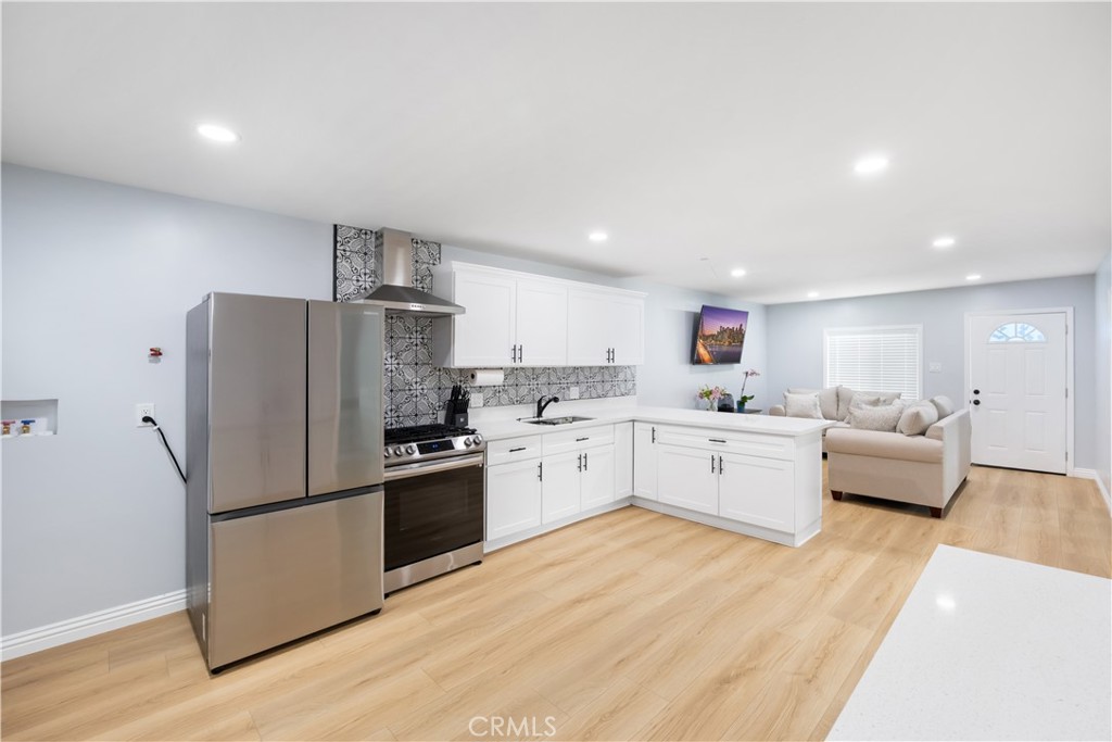 14128 Paramount Boulevard Paramount, CA 90723 - Photo 29 of 42 a kitchen with white cabinets and stainless steel appliances